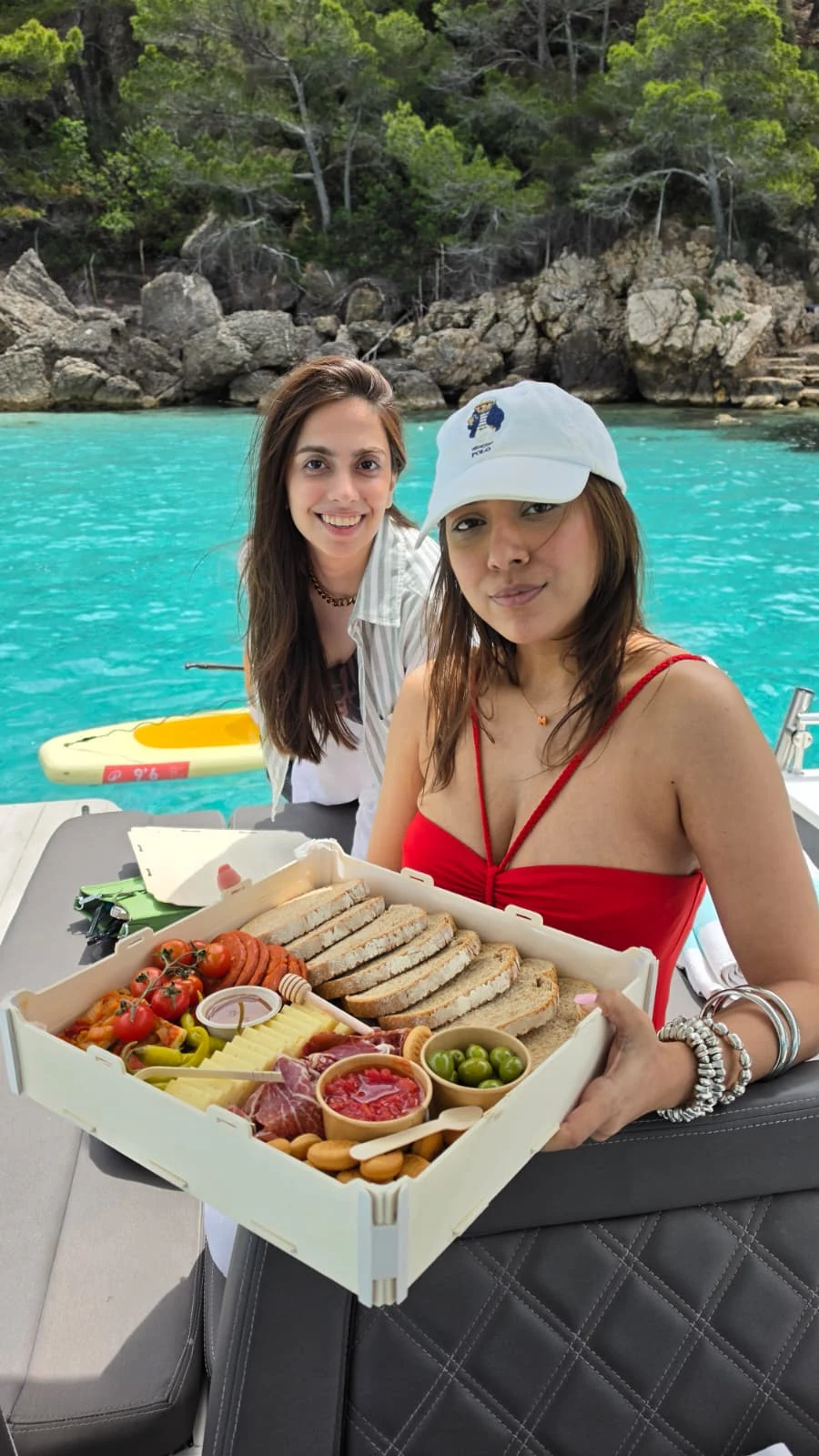 Dos pasajeras muestran una caja de comida preparada a bordo
