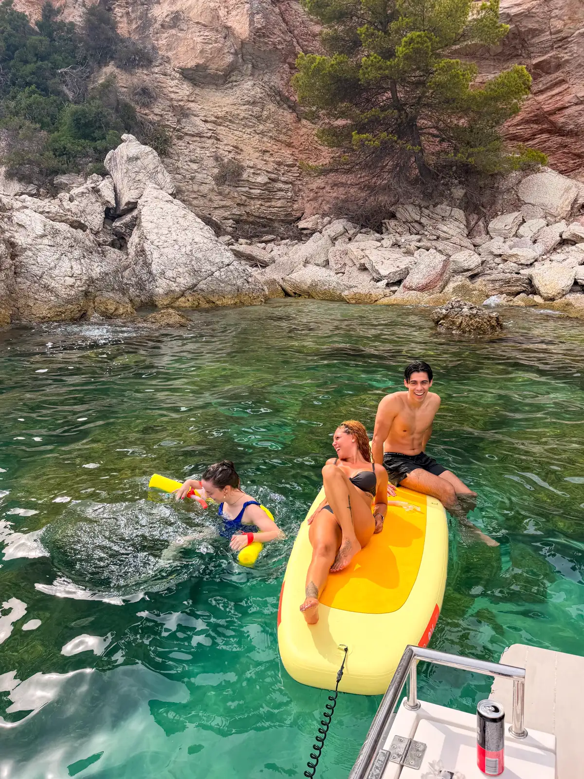 Grupo disfrutando del paddle surf y los flotadores junto al barco